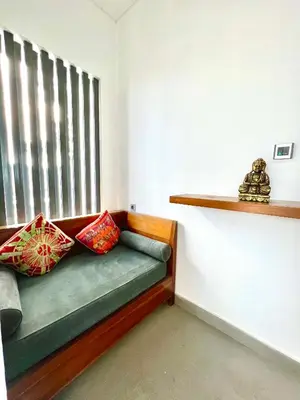 a room with a couch with pillows and a window at Bali Karma Sajtra Hotel in Seminyak