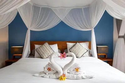 two swans made out of towels sitting on a bed at VILLA SCARLET in Seminyak