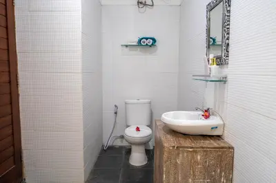 a bathroom with a white toilet and a sink at VILLA SCARLET in Seminyak
