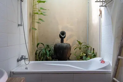 a bathroom with a bath tub with a vase in it at VILLA SCARLET in Seminyak