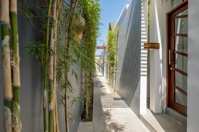 a narrow alley with bamboo plants on the side of a building at PANDAWA VILLAS SEMINYAK in Seminyak