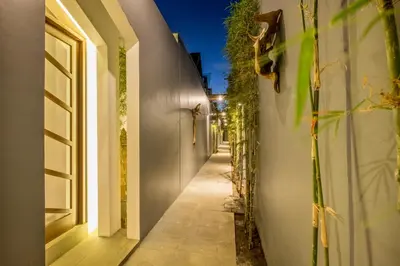 an alleyway of a house with a white wall at PANDAWA VILLAS SEMINYAK in Seminyak