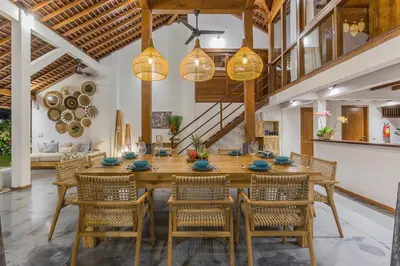 a dining room with a large wooden table and chairs at Villa B in Seminyak