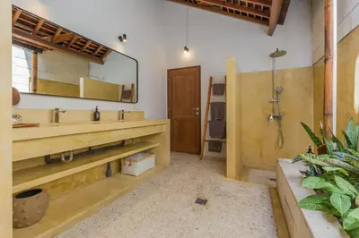 a bathroom with a sink and a shower and a mirror at Villa B in Seminyak