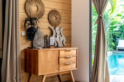 a wooden wall with mirrors and a dresser in a room at Villa Hatari Canggu in Kerobokan