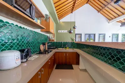 a kitchen with green tile on the wall at CASTELU 3BR peacefully villa near Mertanadi in Seminyak