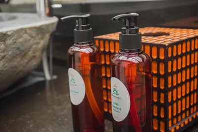 two bottles of liquid sitting next to a wicker basket at Giri Bhagawan Villas & Spa in Nusa Dua