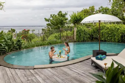 a man and woman in a bath tub in a swimming pool at Giri Bhagawan Villas & Spa in Nusa Dua