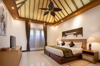 a bedroom with a large bed and a ceiling fan at Giri Bhagawan Villas & Spa in Nusa Dua