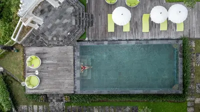 an overhead view of a swimming pool with a person in it at Giri Bhagawan Villas & Spa in Nusa Dua