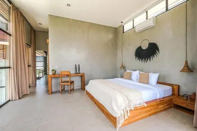 a bedroom with a large bed and a desk at Villa Kamal Umalas in Kerobokan