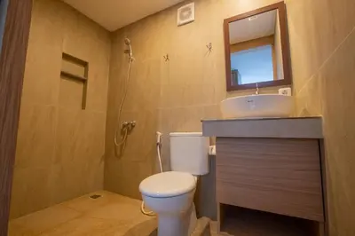 a bathroom with a toilet and a sink and a mirror at Lacrissa Bali in Kerobokan