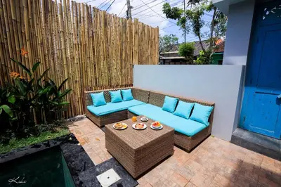 a patio with a blue couch and a table at Lacrissa Bali in Kerobokan