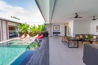 a living room with a swimming pool and a dining room at Villa Lys by Alfred in Bali in Canggu
