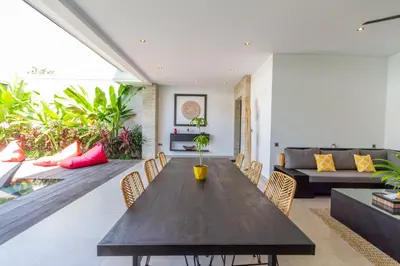 a living room with a wooden table and a couch at Villa Lys by Alfred in Bali in Canggu