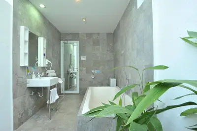 a bathroom with a tub and a sink and a plant at Bali Yarra Villas - Seminyak in Seminyak