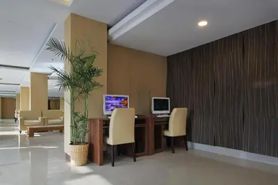 an office with a desk with chairs and a plant at Mars City Hotel in Denpasar