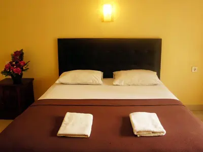 a bedroom with a bed with two towels on it at Waringin Homestay in Kuta