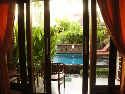 a view of a swimming pool through a window at Waringin Homestay in Kuta