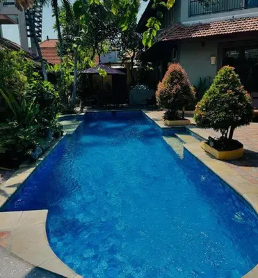 a large blue swimming pool in front of a house at Villa Naga Maya in Legian