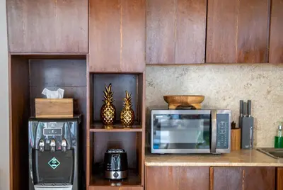 a kitchen counter with a microwave and a coffee maker at CASA MALEH 2BR lively villa in kayuaya seminyak in Seminyak