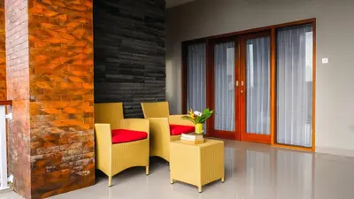 a dining room with yellow chairs and a brick wall at Kubu De Uma in Seminyak
