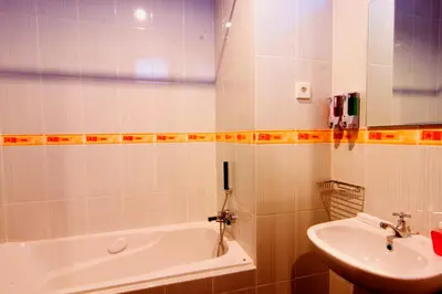 a bathroom with a white tub and a sink at Manggar Indonesia Hotel in Kuta