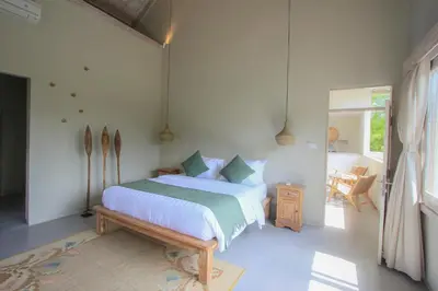 a bedroom with a bed and a wooden bench at Sari Alexa Villas in Seminyak