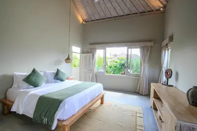 a bedroom with a large bed and a window at Sari Alexa Villas in Seminyak