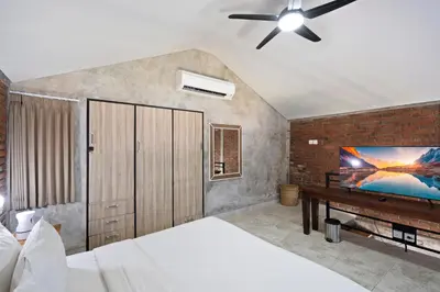 a bedroom with a bed and a flat screen tv at Jaci Residence by Betterplace in Canggu