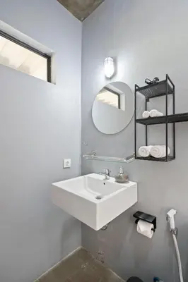 a white bathroom with a sink and a mirror at Jaci Residence by Betterplace in Canggu