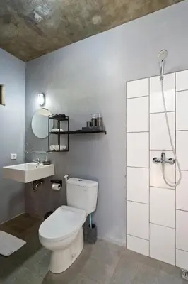 a bathroom with a white toilet and a sink at Jaci Residence by Betterplace in Canggu