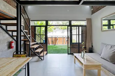 a living room with a staircase and a couch at Jaci Residence by Betterplace in Canggu
