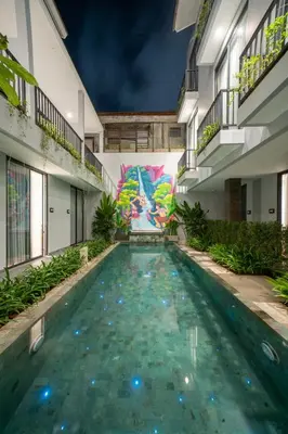 a swimming pool in a building with a painting on the wall at Bestah Coliving in Sanur