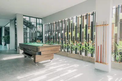 a pool table in a room with windows at Bestah Coliving in Sanur