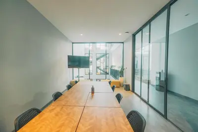 a conference room with a long wooden table and chairs at Bestah Coliving in Sanur