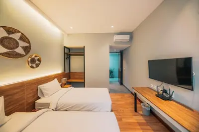 a bedroom with two beds and a flat screen tv at Bestah Coliving in Sanur