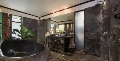 a bathroom with a large tub and a mirror at Phinisi Villas - Seminyak Beach in Seminyak