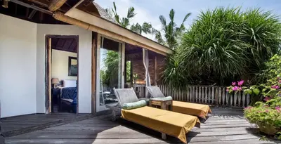 a patio with a couch and chairs on a porch at Phinisi Villas - Seminyak Beach in Seminyak