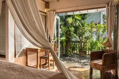 a bedroom with a bed and a sliding glass door at Villa Istimewa in Seminyak