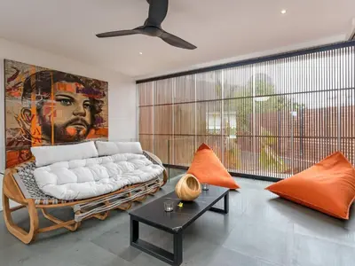 a living room with a white couch and a painting at Villa Castil di Udara by Villa Finder in Kerobokan