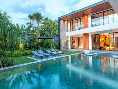a house with a swimming pool next to a house at Villa Castil di Udara by Villa Finder in Kerobokan