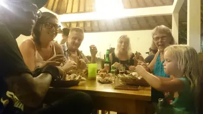 a group of people sitting at a table eating food at Puri Clinton Bali in Nusa Dua