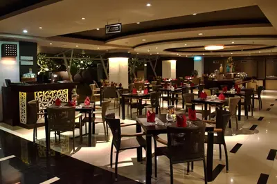a dining room with tables and chairs in a restaurant at The Kana Kuta Hotel in Kuta