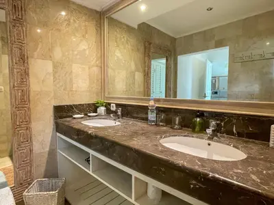 a bathroom with two sinks and a large mirror at Beach House Canggu - 150m Berawa beach in Canggu