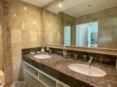 a bathroom with two sinks and a large mirror at Beach House Canggu - 150m Berawa beach in Canggu