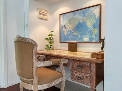 a desk with a chair and a map on the wall at Beach House Canggu - 150m Berawa beach in Canggu