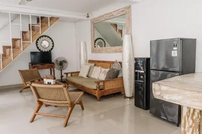a living room with a couch and a refrigerator at Mara Villa, Garden & Pool, 2 min to Seminyak Beach in Seminyak