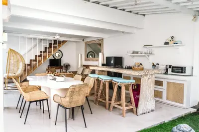 a kitchen with a counter and chairs and a table at Mara Villa, Garden & Pool, 2 min to Seminyak Beach in Seminyak