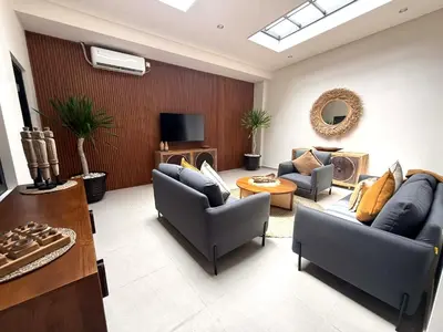 a living room with two couches and a tv at de CINTA Villa - KUTA - 6 bedrooms - Heart of Kuta in Kuta